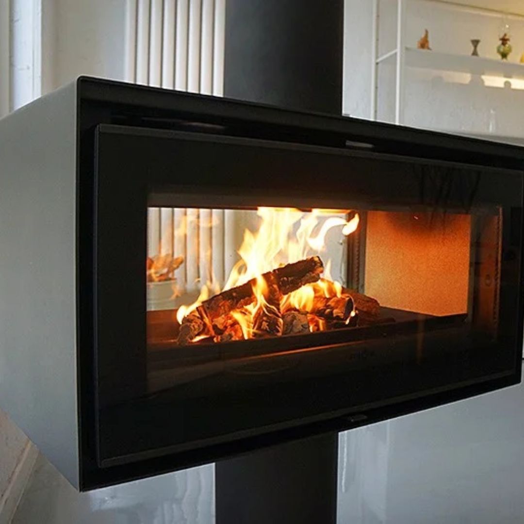 Modern fireplace with burning logs inside a glass door.